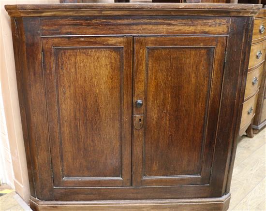 An early 19th century oak corner cupboard W.109cm